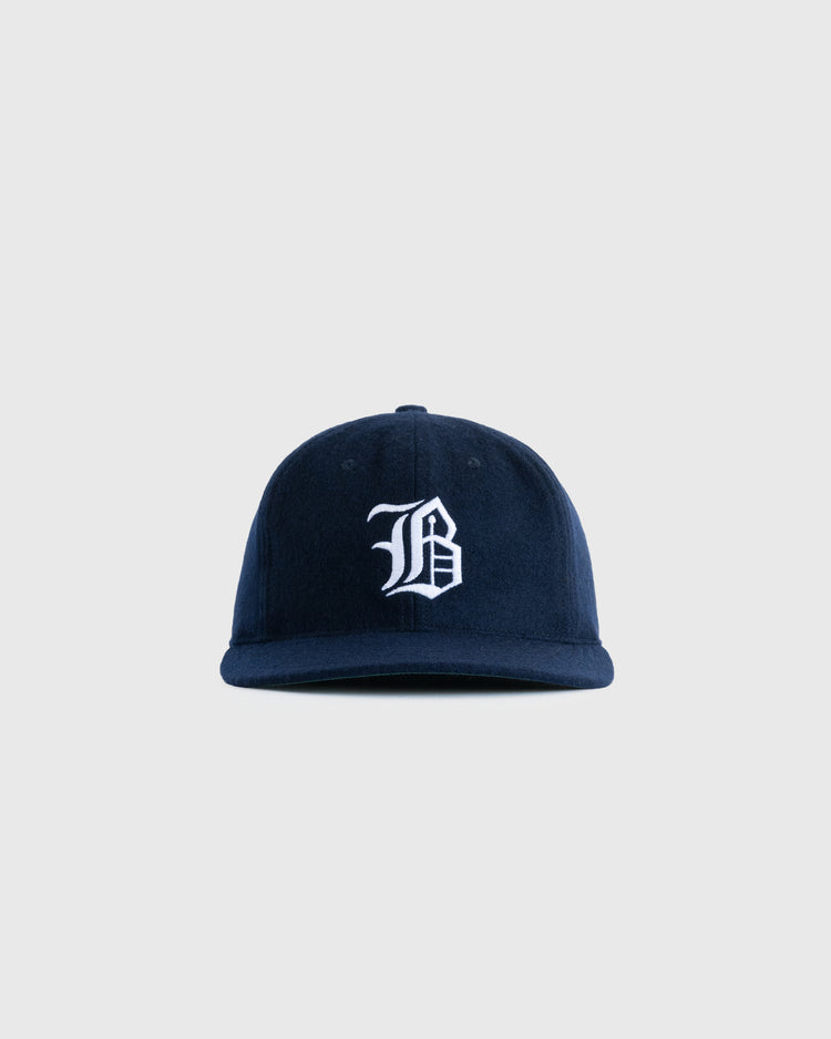 The EFF Buffalo Bisons 1959 Authentic Wool Ballcap features a navy blue design with a white embroidered gothic B on the front, inspired by the original 1959 cap and shown against a plain light gray background.
