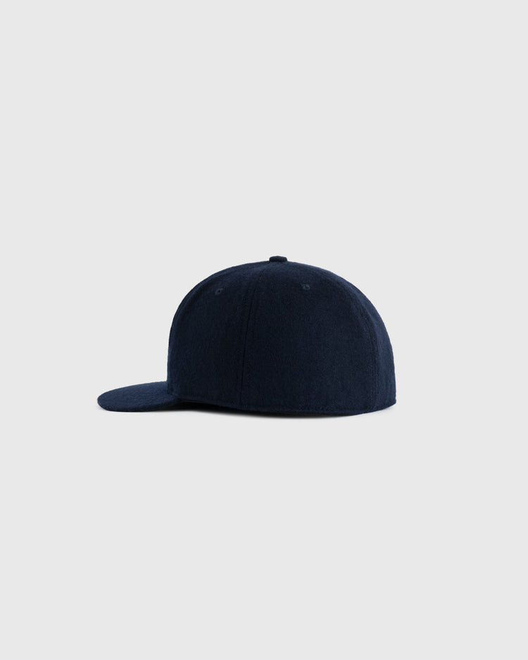 The EFF Richmond Virginians 1961 Authentic Wool Ballcap, shown from the side with a curved brim and plain dark navy design, is an authentic reproduction vintage baseball cap set against a light gray background.
