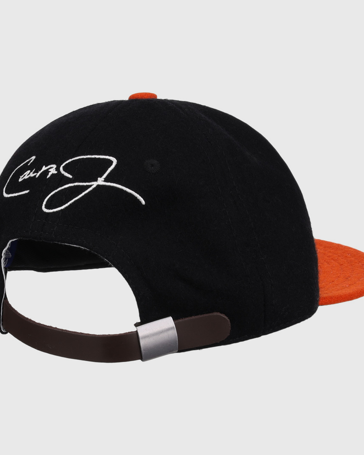 The Ebbets Field Flannels Cal Ripken Jr. Signature Series Ballcap features a vintage black and orange wool design, brown adjustable strap, and a white embroidered signature on the back panel.