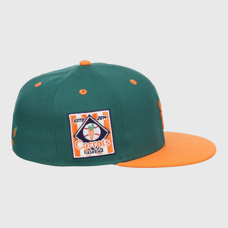 The EFF Carrots Arlington Heights Collection Logo Fitted Ballcap is a green cap with an orange brim and button, featuring a baseball patch with carrot graphic and ESTD 2014, plus a side carrot logo honoring the Arlington Heights Carrots legacy.