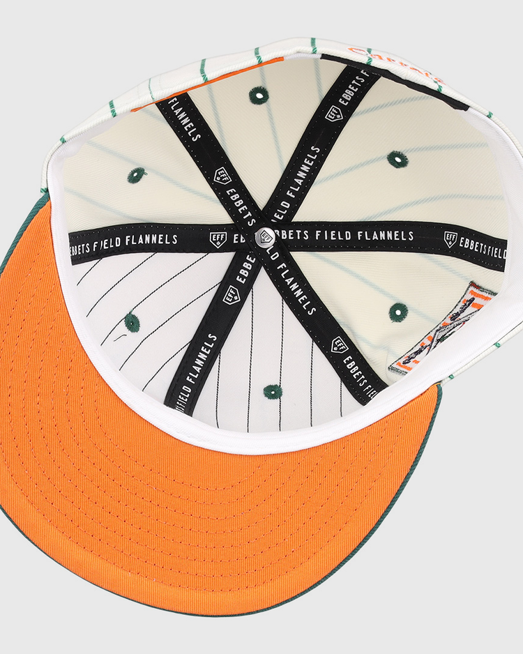 Interior view of the Carrots Arlington Heights Collection Pinstripe Fitted Ballcap by EFF, featuring orange brim stitching, green stripes and vents, plus black bands with the “EBBETS FIELD FLANNELS” logo from a brand collaboration.