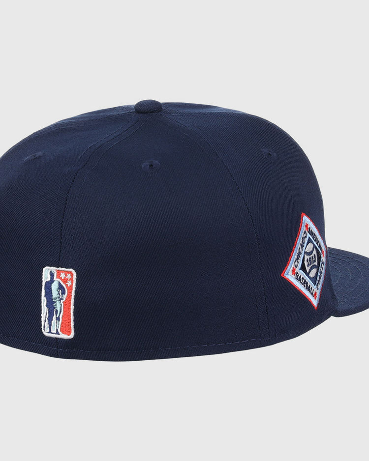 The EFF Chicago American Giants NLB Team Color Fitted Ballcap is a navy blue crown cap with a flat brim, featuring a silhouette logo patch on the back and a diamond-shaped text logo patch on the side, inspired by vintage NLB Flip styles.