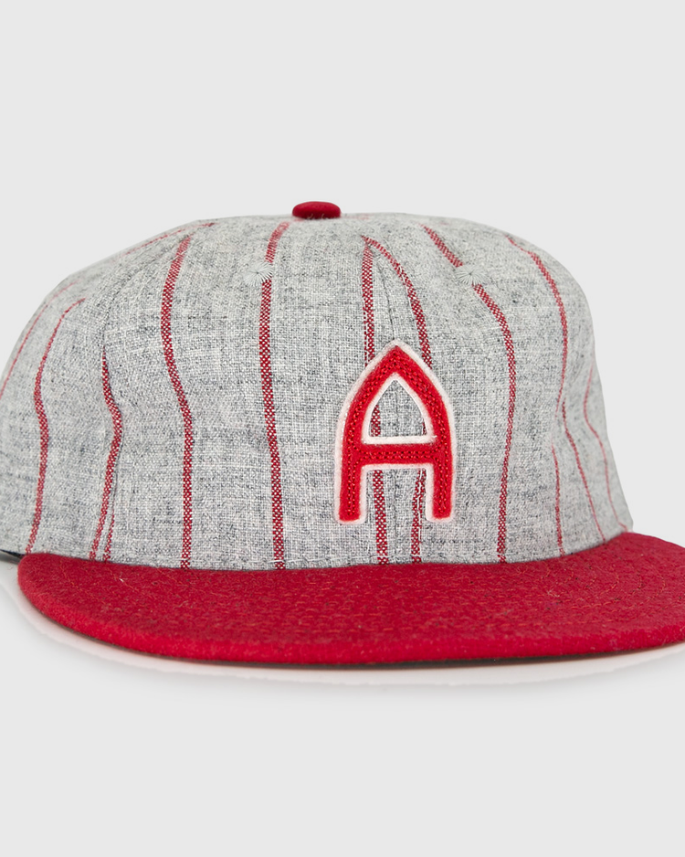 The Club Artemisa 1943 Vintage Ballcap by Ebbets Field Flannels features genuine grey wool, thin red stripes, a red brim, and a bold red A on the front, inspired by the Cuban National Amateur League team.