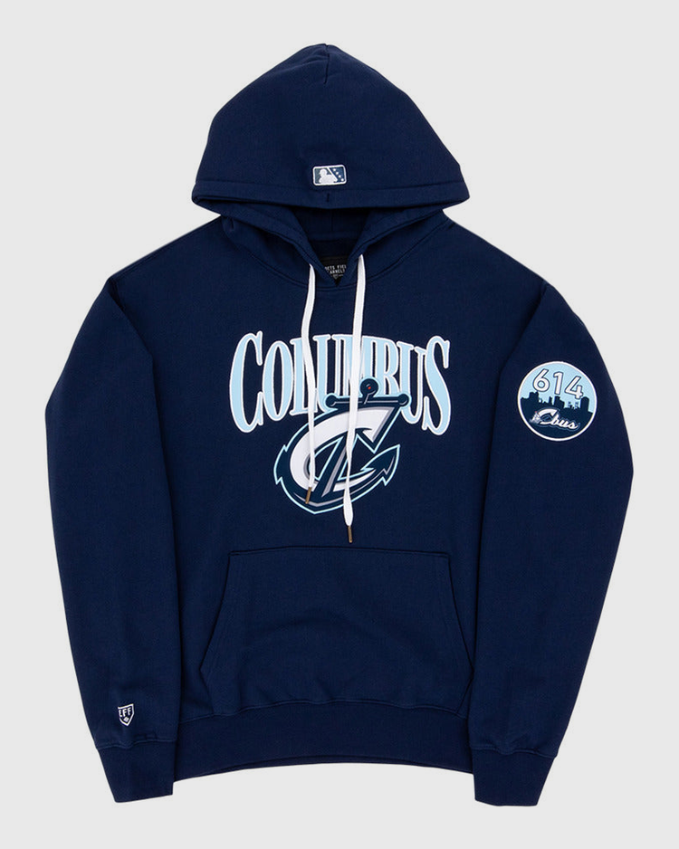 The Ebbets Field Columbus Clippers MiLB Cotton Hooded Sweatshirt is a navy blue hoodie with white drawstrings, COLUMBUS and a stylized C logo on the front, a circular 614 Class patch on the left sleeve, and a small logo near the left wrist.