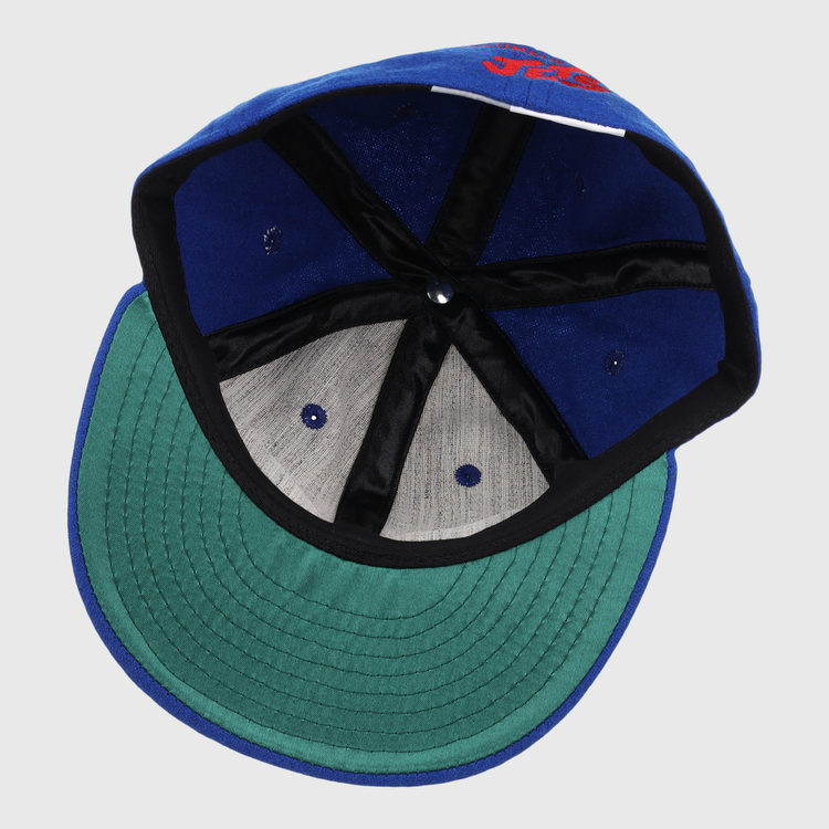 The EFF Columbus Jets Letterhead Wool Vintage Ballcap features a blue wool build, green brim, black inner seams, grey panels, and a white inner tag—capturing the classic style of vintage Minor League baseball caps.