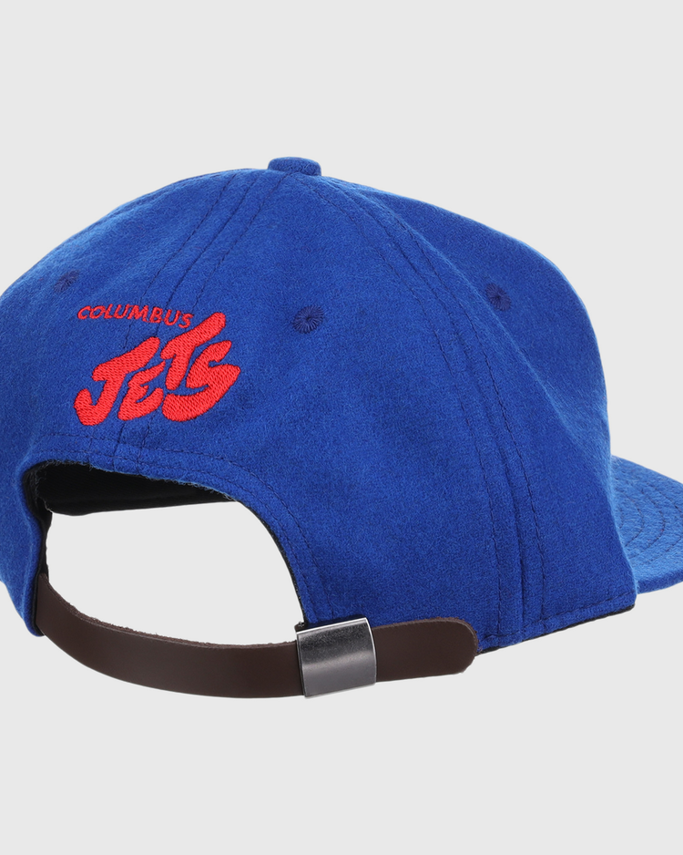 The EFF Columbus Jets Letterhead Wool Vintage Ballcap is a blue Minor League hat viewed from the back, featuring red embroidered COLUMBUS JETS text and a brown adjustable strap with metal clasp.