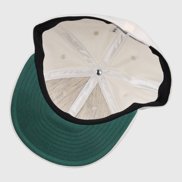 The image shows the inside of an EFF Cream Wool Vintage Ballcap, featuring a green underbrim, black inner band, visible stitching and seams, and a silver button at the crown of this classic cap.