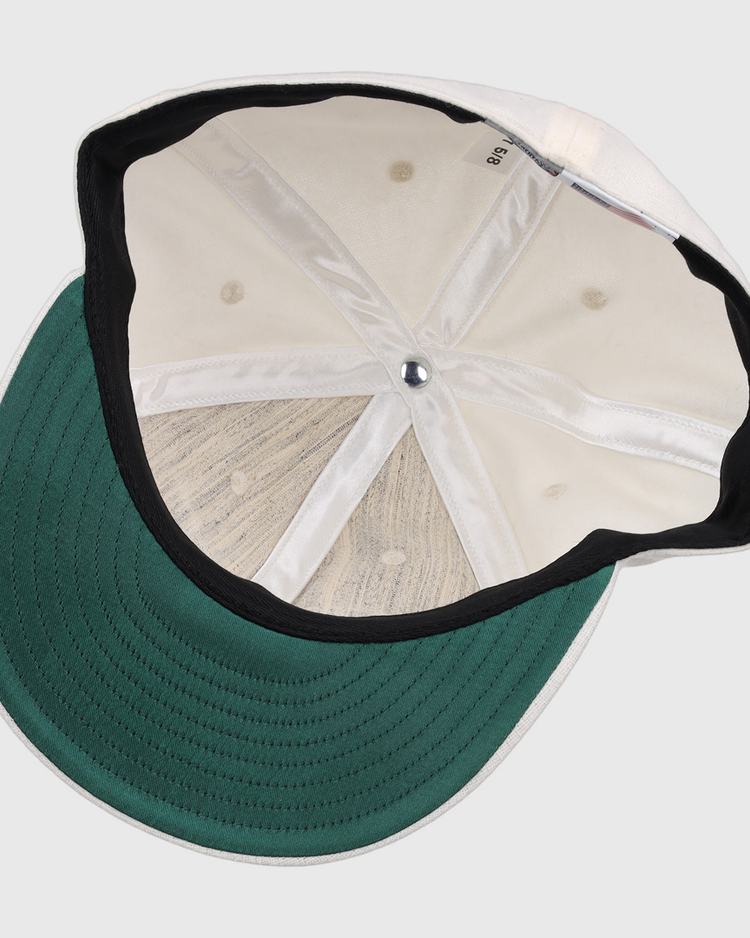 The image shows the inside of an EFF Cream Wool Vintage Ballcap, featuring a green underbrim, black inner band, visible stitching and seams, and a silver button at the crown of this classic cap.