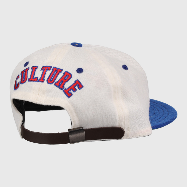 The EFF Cultural Excellence x Philadelphia Stars Wool Ballcap is a white cap with a blue brim, blue stitched eyelets, “CULTURE” embroidered in red and blue on the back, and an adjustable brown strap with metal clasp. Inspired by Negro League Baseball.