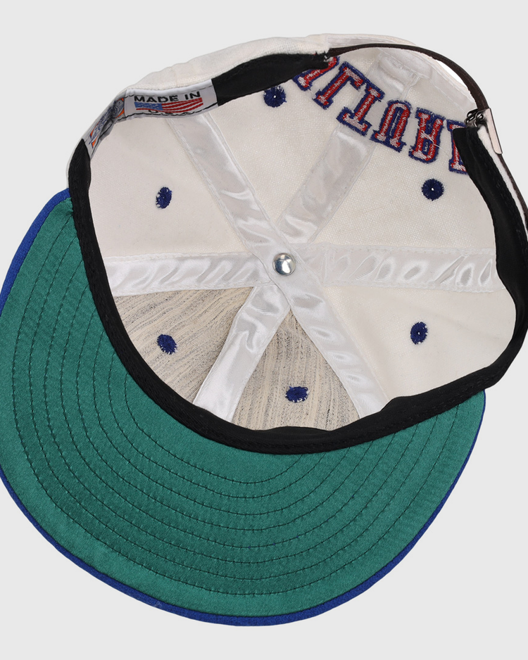 The EFF Cultural Excellence x Philadelphia Stars Wool Ballcap is turned inside out, revealing its interior stitching, a green brim underside, white crown, navy blue ventilations holes, and a MADE IN tag—classic Negro League Baseball style.