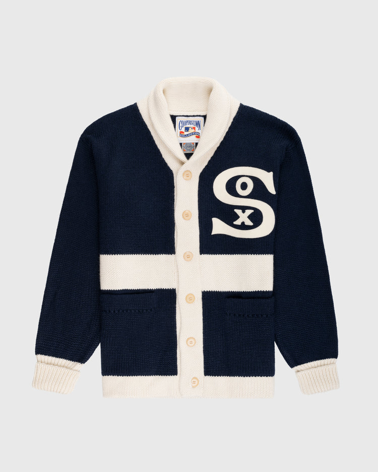 The EFF Chicago White Sox 1926 Wool Shawl Collar Sweater features navy blue wool, cream trim and buttons, two front pockets, a shawl collar, and a large cream Sox logo on the chest. Inspired by the 1926 team sweater.