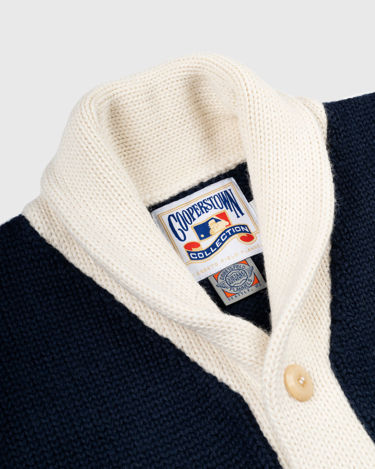 Close-up of the EFF Chicago White Sox 1926 Wool Shawl Collar Sweater in navy and cream, featuring cream buttons and a Cooperstown Collection label, inspired by a vintage baseball style.