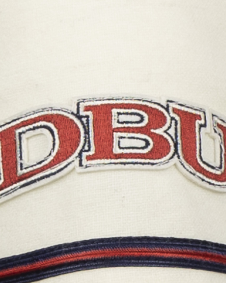 The EFF Dallas Baptist University Home Jersey features a cream base with bold red DBU letters outlined in blue, and navy and red stripes below, evoking a classic collegiate style.
