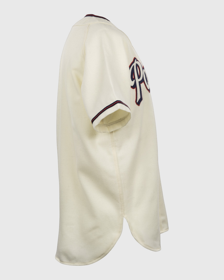 The EFF Dallas Baptist University Home Jersey is shown from the side in cream, with dark sleeve trim and partial lettering across the chest.