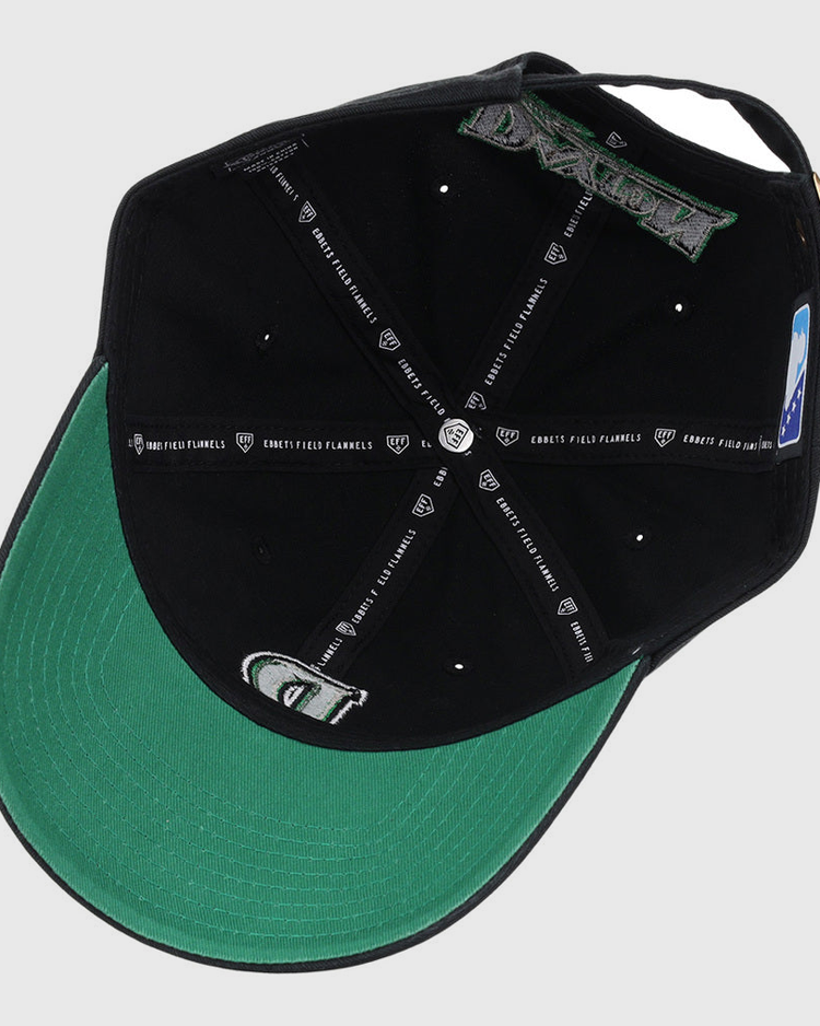 The image shows the inside view of an Ebbets Field Dayton Dragons MiLB Dad Ballcap. It features black panels, white stitching, branded taping, a green underbill, and an adjustable strap at the back.
