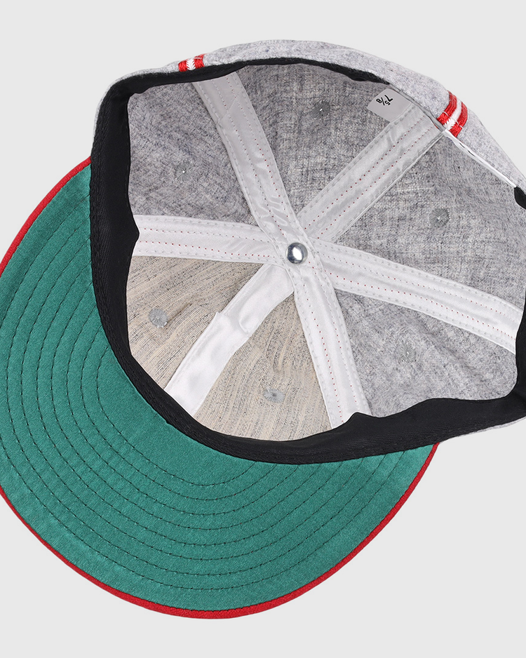 A top-down view of the Ebbets Field Flannels Daytona Beach Islanders 1936 Vintage Ballcap shows a gray cap with a green underside brim, red and white striped edges, and visible inner stitching and fabric panels.