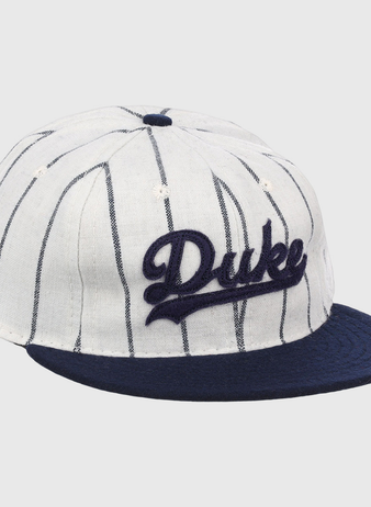 The EFF Duke University Pinstripe Script Vintage Ballcap features thin navy pinstripes on white, a navy brim, and Duke embroidered in navy script for a classic baseball look.