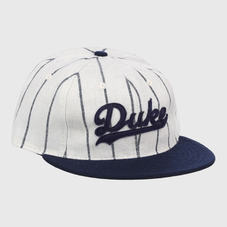 The EFF Duke University Pinstripe Script Vintage Ballcap features thin navy pinstripes on white, a navy brim, and Duke embroidered in navy script for a classic baseball look.