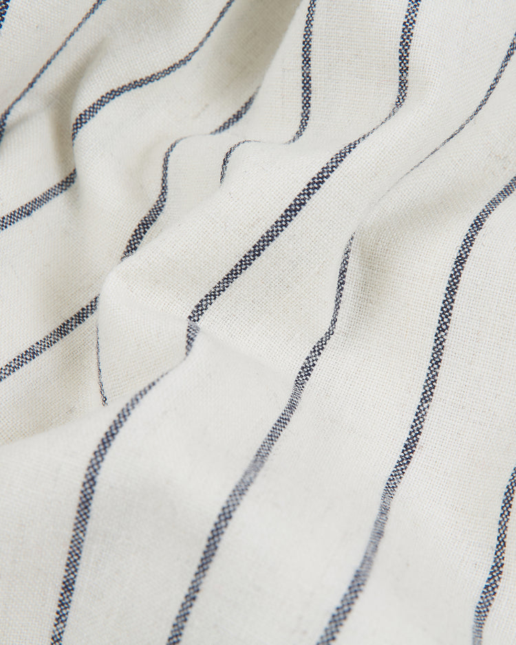 A close-up of the New York Cubans 1935 Authentic Wool Road Jersey by Ebbets Field reveals white fabric featuring thin, evenly spaced black vertical stripes and gentle, soft folds—evoking the classic wool baseball jersey style iconic to the Negro League era.