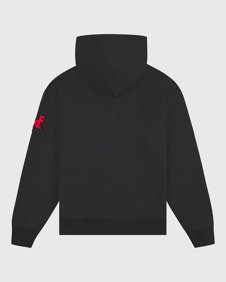 The New York Cubans Heavyweight Cotton Terry Pullover Hoodie by Ebbets Field is shown from the back in black, featuring a bright pink graphic or logo on the left sleeve. This heavyweight cotton hoodie has a plain back with no visible patterns or text, making it a versatile addition to any Negro League apparel collection.