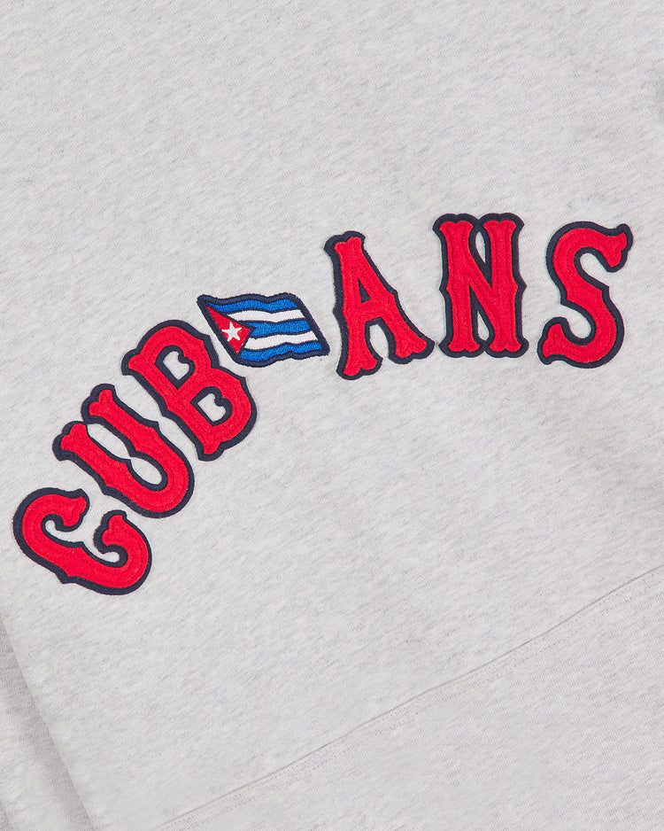 The Ebbets Field New York Cubans Heavyweight Cotton Terry Pullover Flag Hoodie showcases “CUBANS” in bold red outlined letters, with the letter B cleverly replaced by a small Cuban flag—a standout homage to Negro League heritage and classic New York Cubans hoodie styles.