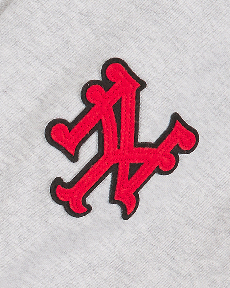 The Ebbets Field New York Cubans Heavyweight Cotton Terry Pullover Flag Hoodie features a red and black embroidered monogram with two interlocking, stylized A and N letters on light gray cotton, drawing inspiration from classic Negro League apparel.