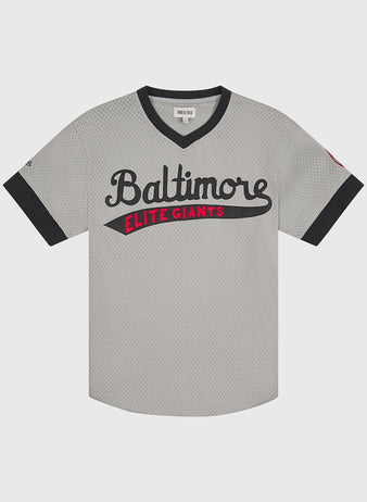 The Ebbets Field Baltimore Elite Giants 1949 V-Neck Mesh Road Jersey features a gray body with black trim, “Baltimore” in black script and “Elite Giants” in red block letters across the chest. This Negro League jersey has short sleeves and a V-neck, faithfully reproducing the style worn by the 1949 Baltimore Elite Giants.