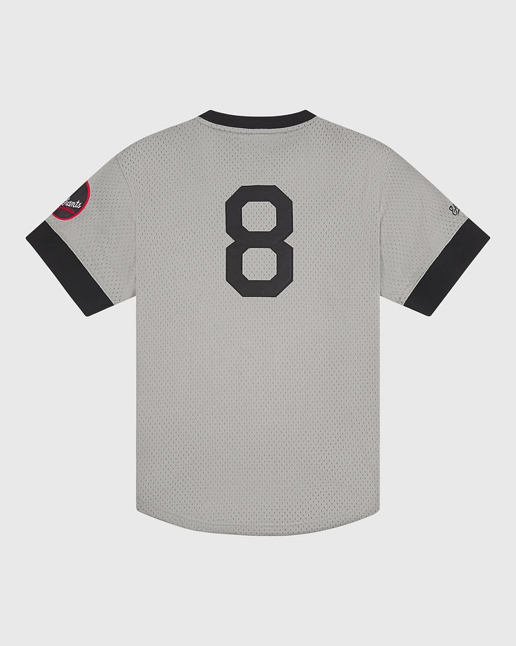 The Ebbets Field Baltimore Elite Giants 1949 V-Neck Mesh Road Jersey features a gray mesh fabric with black trim, the number 8 on the back, a red patch on the left sleeve, and a small logo on the right sleeve—an authentic recreation that captures the iconic style of the original Negro League jersey.