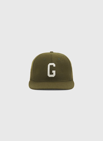 The Homestead Grays 1945 Authentic Wool Ballcap by Ebbets Field features an olive green wool design with a flat brim and a prominent white “G” embroidered on the front, shown against a plain light gray background.