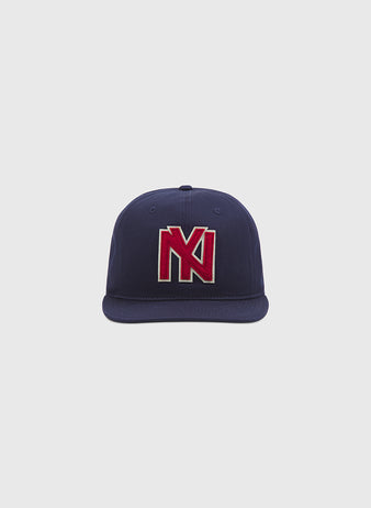 The Brooklyn Eagles Cotton Twill Ballcap by Ebbets Field is a navy blue baseball cap with a striking red and white embroidered “N” and “K” logo on the front, shown against a plain light gray background.