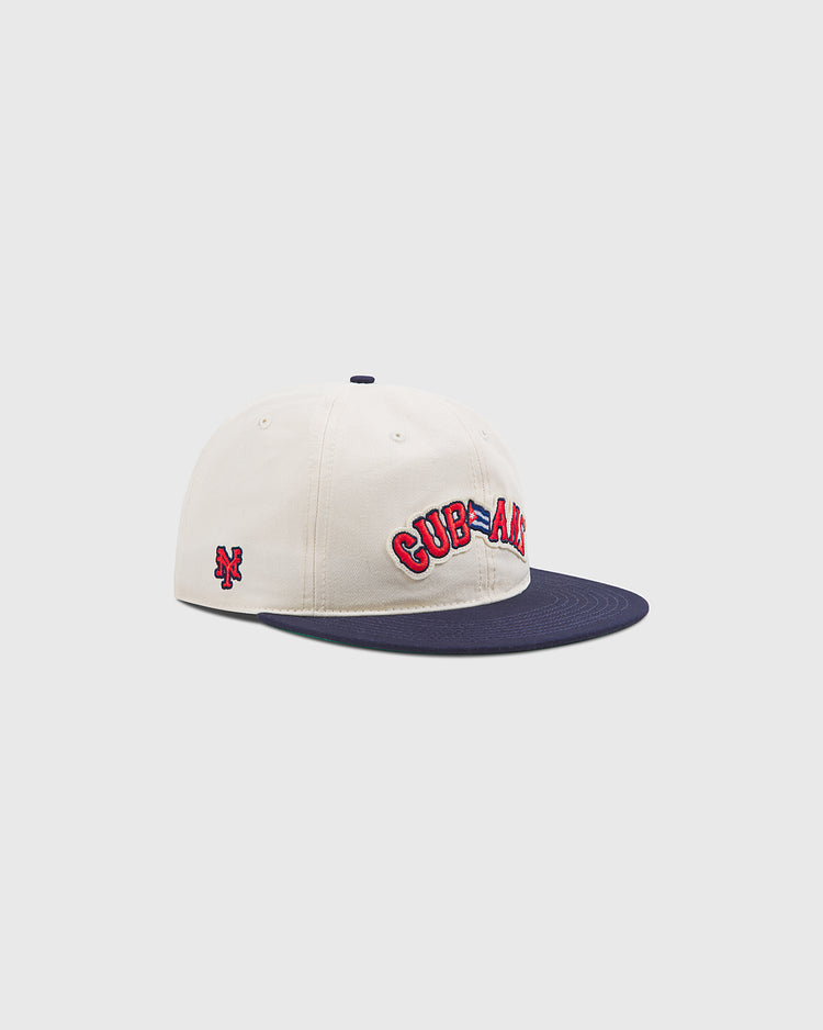 Introducing the New York Cubans Authentic Cotton Ballcap by Ebbets Field—a cream cotton twill baseball cap featuring a navy brim, inspired by the classic New York Cubans ballcap. The front showcases “CUBA ALL” embroidered in red and blue, while a small NY logo is stitched on the side as a tribute to its Negro League heritage. Displayed against a light gray background.