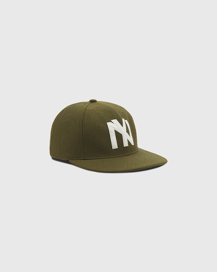 The Ebbets Field Brooklyn Eagles 1935 Wool Ballcap features an olive green design with a flat brim and bold white NY lettering on the front, evoking the classic style of vintage baseball caps. It is displayed against a plain light grey background.