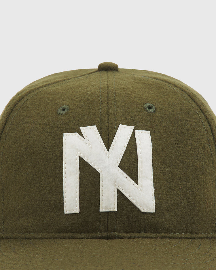 The Ebbets Field Brooklyn Eagles 1935 Wool Ballcap features an olive green wool construction with a white, stylized NY logo stitched on the front, set against a plain, light background—a classic design inspired by the caps worn by the 1935 Brooklyn Eagles of the Negro Leagues.