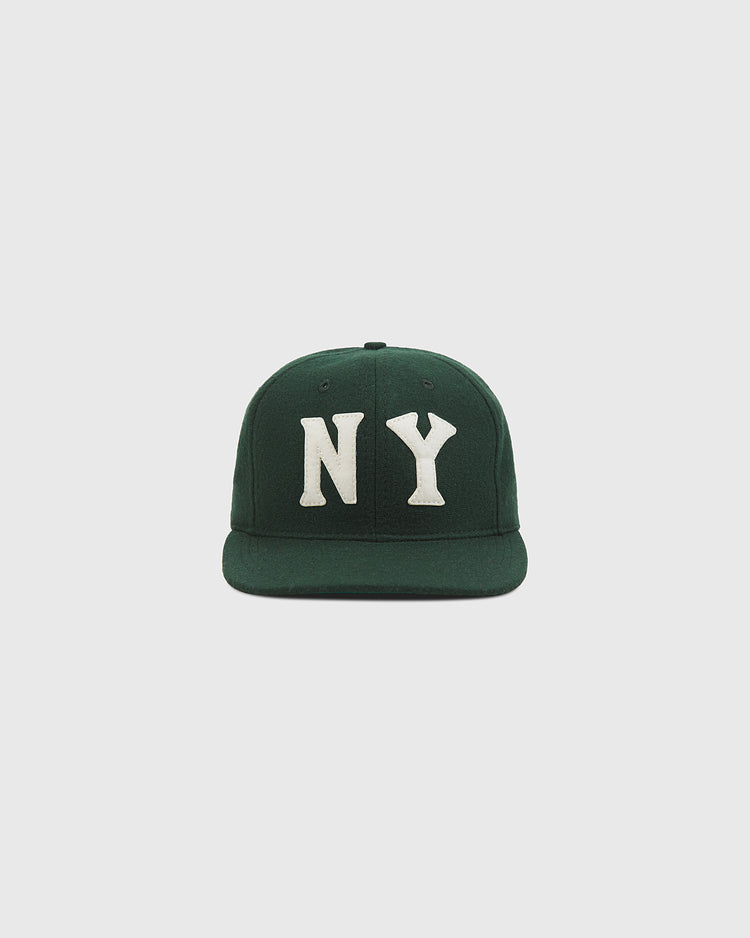The Ebbets Field NY Black Yankees Authentic Wool Ballcap, featuring a dark green wool construction and bold white “NY” lettering on the front inspired by the New York Black Yankees of the Negro National League, is displayed against a plain light gray background.