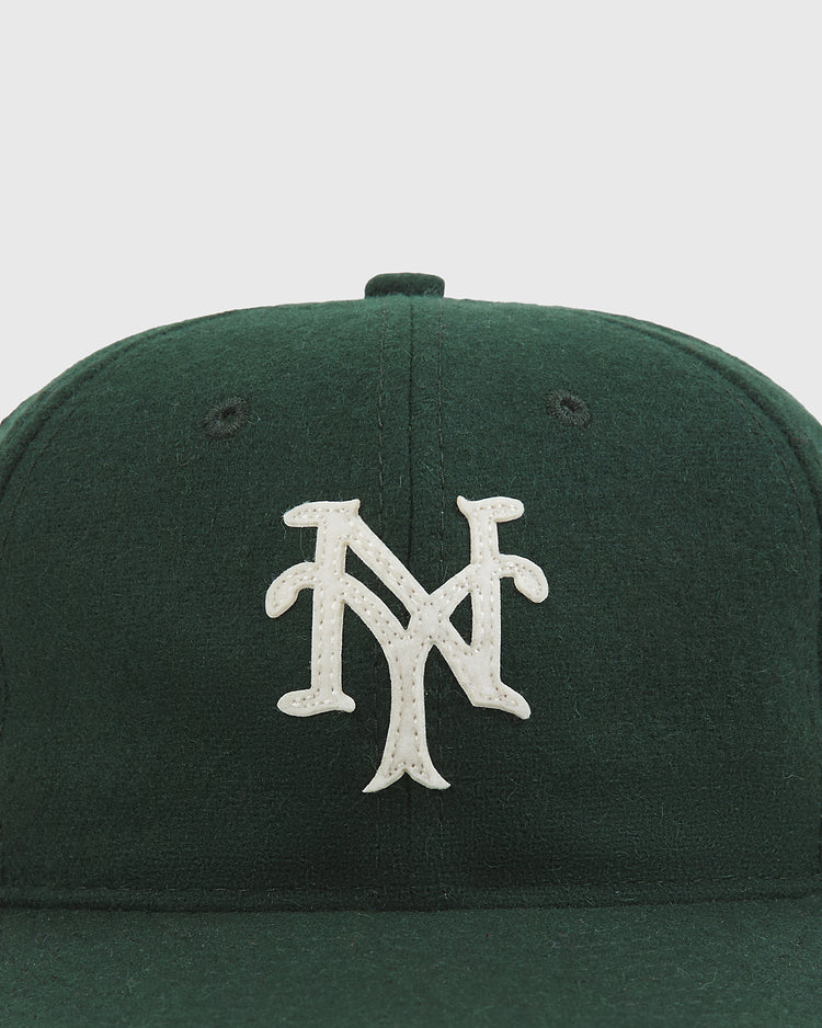 An Ebbets Field New York Cubans Authentic Wool Ballcap in dark green, featuring a white, stylized interlocking NY logo on the front, displayed against a light background.