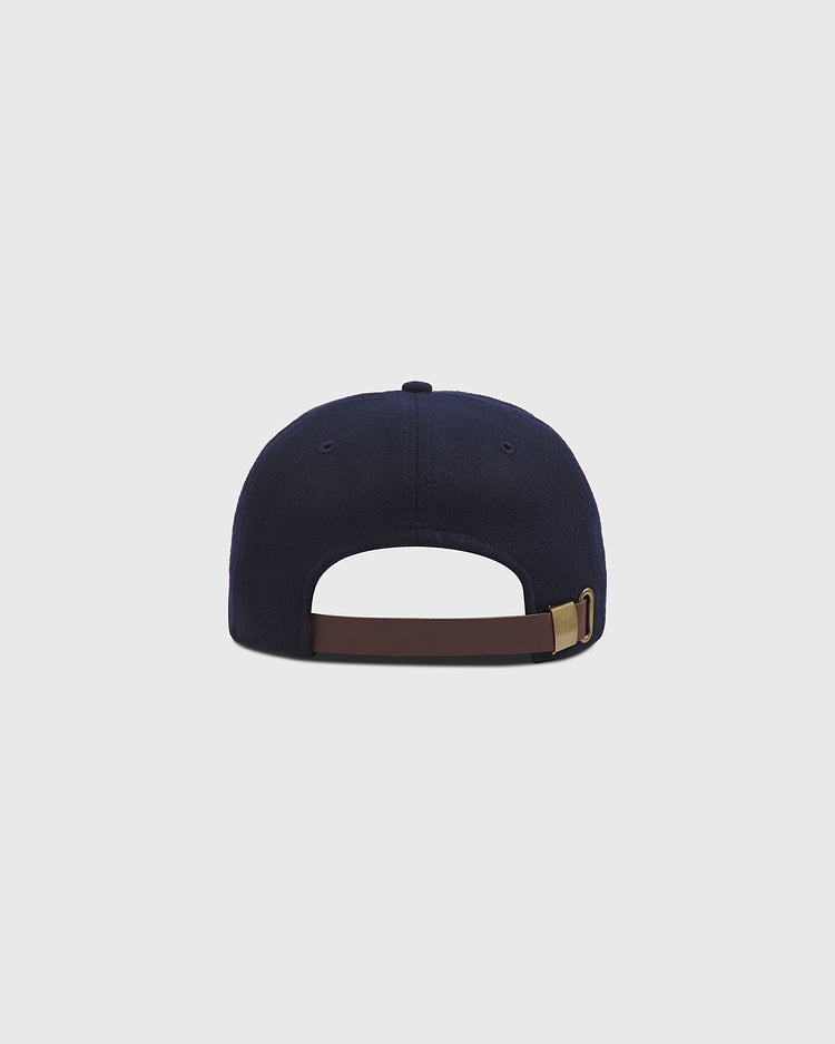 A New York Cubans Authentic Wool Ballcap by Ebbets Field, crafted in navy blue wool, is shown from the back with a brown adjustable strap and metal buckle, set against a plain light gray background. This classic design draws inspiration from vintage Negro National League styles.