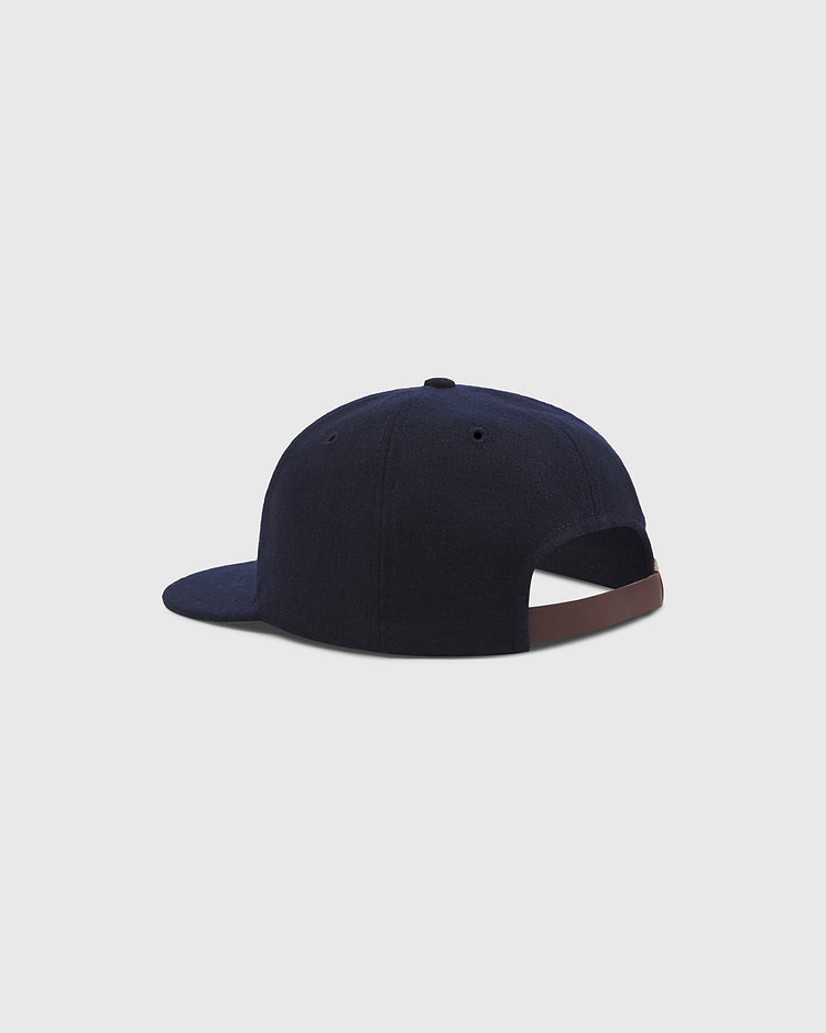 A Brooklyn Royal Giants Authentic Wool Ballcap by Ebbets Field is shown from the back against a light gray background, featuring a navy blue color, a curved brim, and an adjustable brown strap.