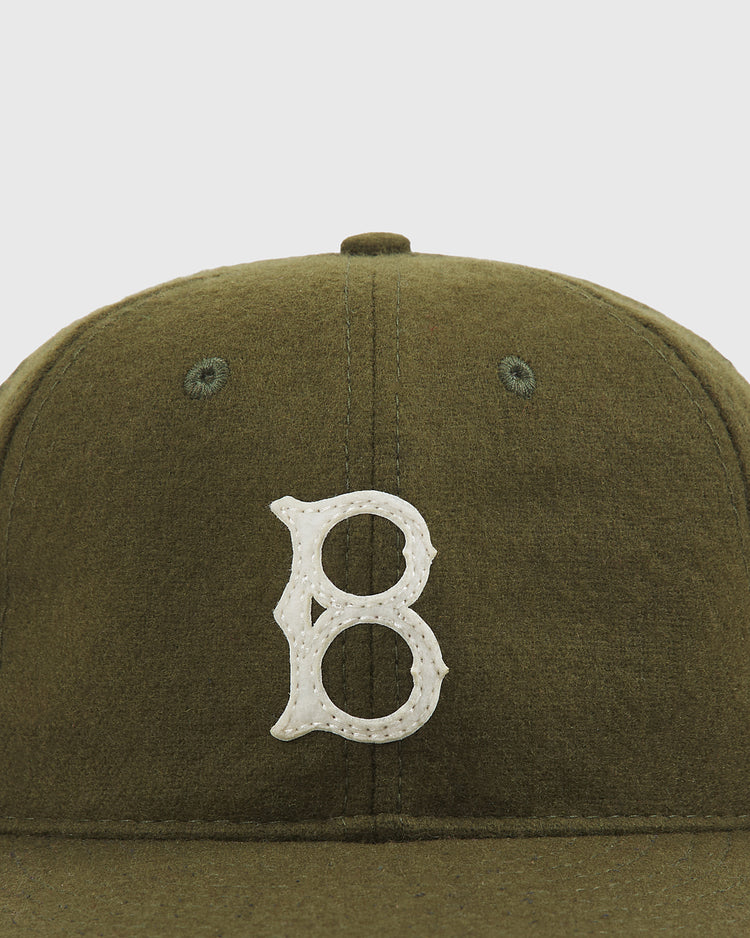 The Brooklyn Royal Giants Authentic Wool Ballcap by Ebbets Field features an olive green wool construction with a soft texture and visible seam stitching. A white embroidered “B” on the front pays tribute to the Brooklyn Royal Giants, honoring Black baseball history with classic style.