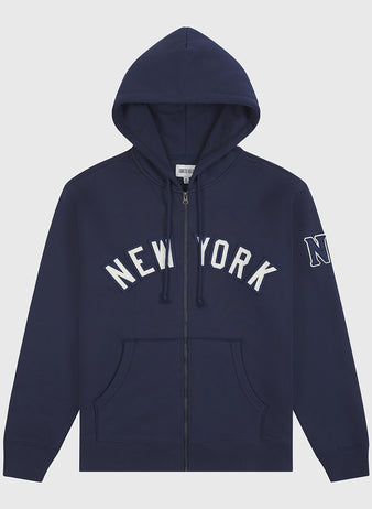 The Ebbets Field Black Yankees Heavyweight Cotton Terry Full-Zip Hoodie features a navy blue design with “NEW YORK” in white block letters across the chest, an “N” patch on the left sleeve, front pockets, and a drawstring hood—drawing inspiration from classic Negro League apparel.
