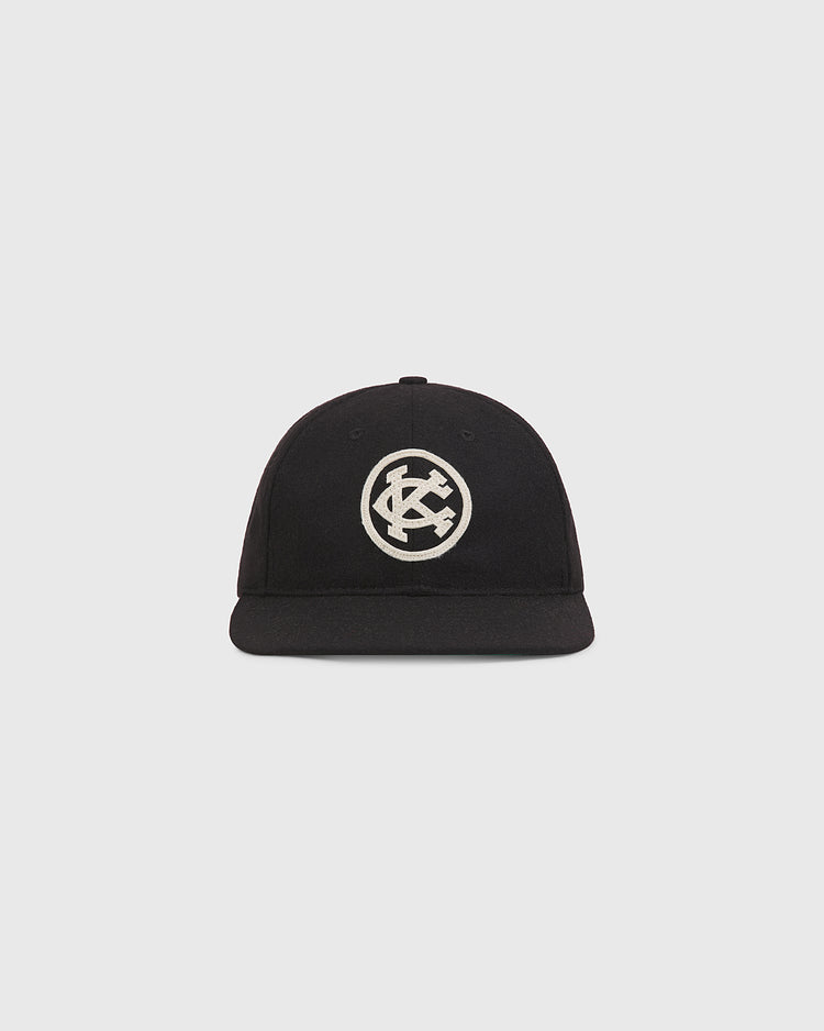Ebbets Field Kansas City Monarchs 1924 Authentic Wool Ballcap, a black wool baseball cap with an off-white circular patch featuring an interlocking KC logo on the front.