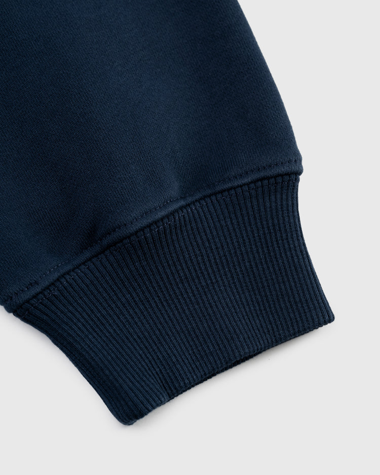 Close-up of the sleeve cuff on the Ebbets Field New York Black Yankees Embroidered NY Heavyweight Cotton Terry Pullover Hoodie, highlighting its ribbed navy blue fabric texture against a light grey background.