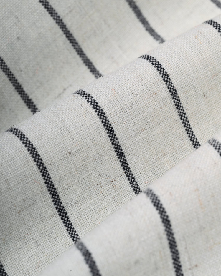 Close-up of cream-colored fabric with evenly spaced, thin black vertical stripes, highlighting the texture and folds of the Ebbets Field New York Black Yankees 1942 Authentic Wool Home Baseball Jersey.