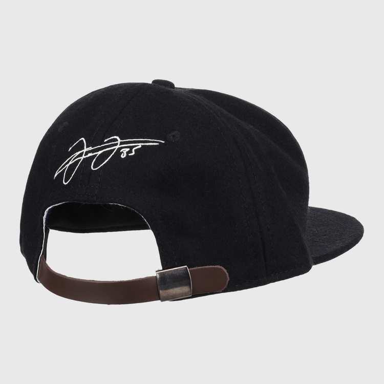 The Ebbets Field Flannels Frank Thomas Signature Series Ballcap in black is shown from the back, highlighting its brown adjustable strap with metal clasp and a white embroidered Frank Thomas signature on the rear panel.