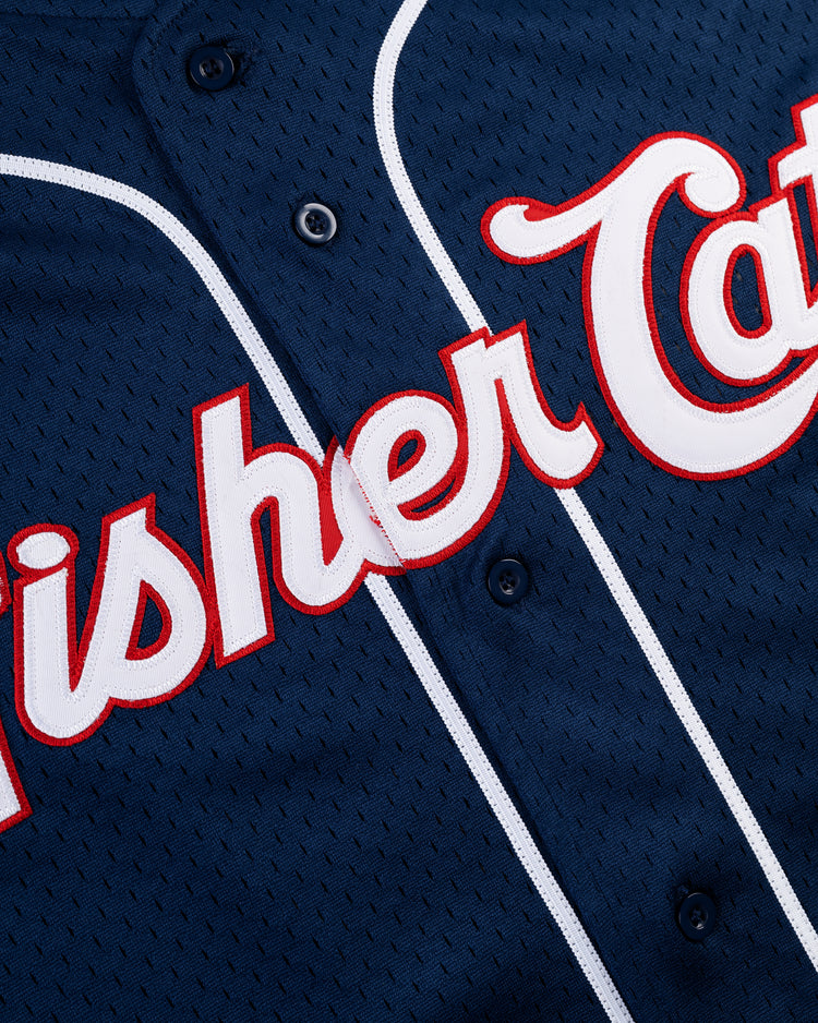 Close-up of the Ebbets Field VLAD GUERRERO JR BUTTON UP MESH JERSEY in navy, featuring white piping and red-trimmed white script text with part of Fisher Cats visible across the chest.