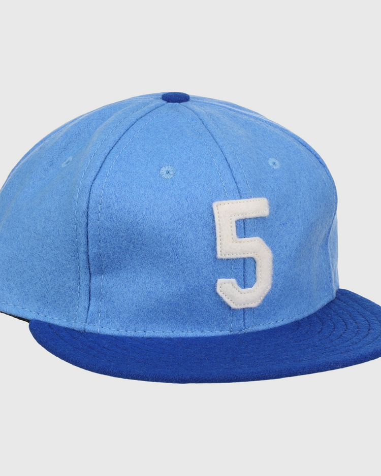 The Ebbets Field Flannels George Brett Signature Series Ballcap features vintage light blue wool, a dark blue brim, and a white number 5 on the front, inspired by classic styles from the National Baseball Hall of Fame.