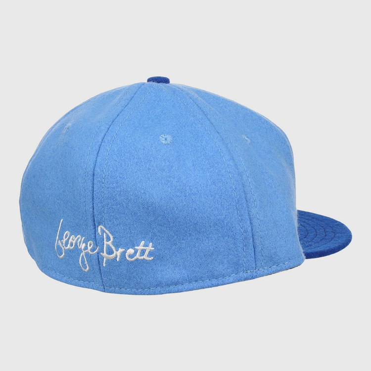 The Ebbets Field Flannels George Brett Signature Series Ballcap features a light blue vintage wool crown, darker blue brim, and white script embroidery of George Brett’s signature—a tribute to the Hall of Fame legend.