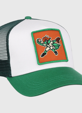 The Greensboro Grasshoppers MiLB Trucker Ballcap by Ebbets Field is a green and white mesh-back hat featuring a front patch with a cartoon leprechaun mascot in a fighting stance on an orange background.