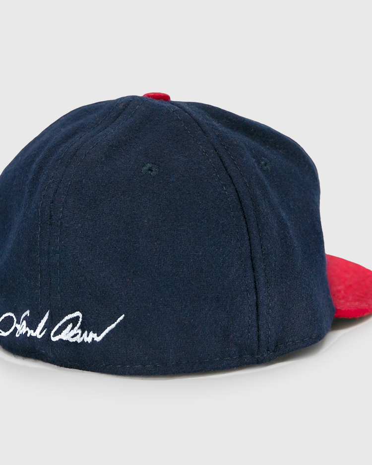 The Ebbets Field Flannels Hank Aaron 1957 Signature Series Ballcap is a vintage-style navy wool cap with a red brim and Hank Aaron’s signature embroidered in white on the back, made in the USA.