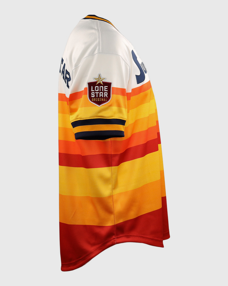 The Harlingen Suns EFF Lone Star Baseball Jersey by EFF features red, orange, yellow, and white horizontal stripes and a Lone Star patch on the sleeve, inspired by Texas baseball and the Harlingen Suns of the Lone Star League. Shown in side view.