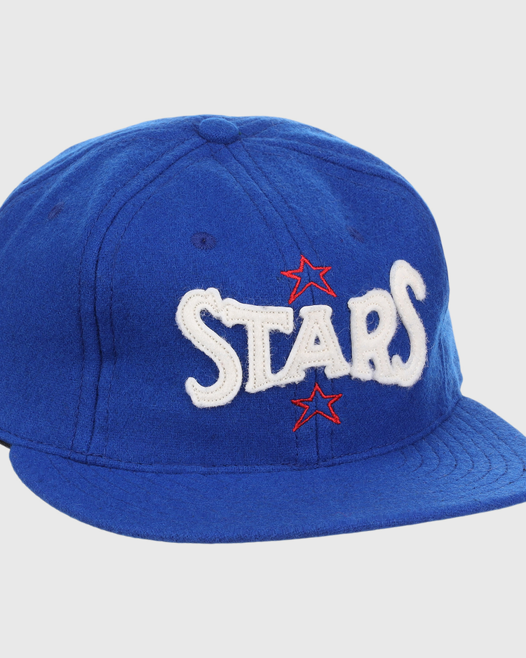 The EFF Hollywood Stars Letterhead Wool Vintage Ballcap is a blue wool hat featuring STARS in large white letters and two red stars, inspired by the classic Pacific Coast League Hollywood Stars cap.